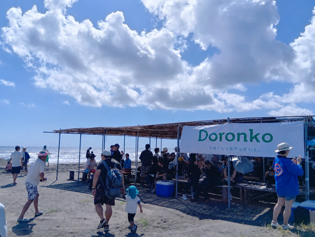 砂浜に休憩できるベンチとテーブル。屋根からはDoronkoと書かれた横断幕がついている